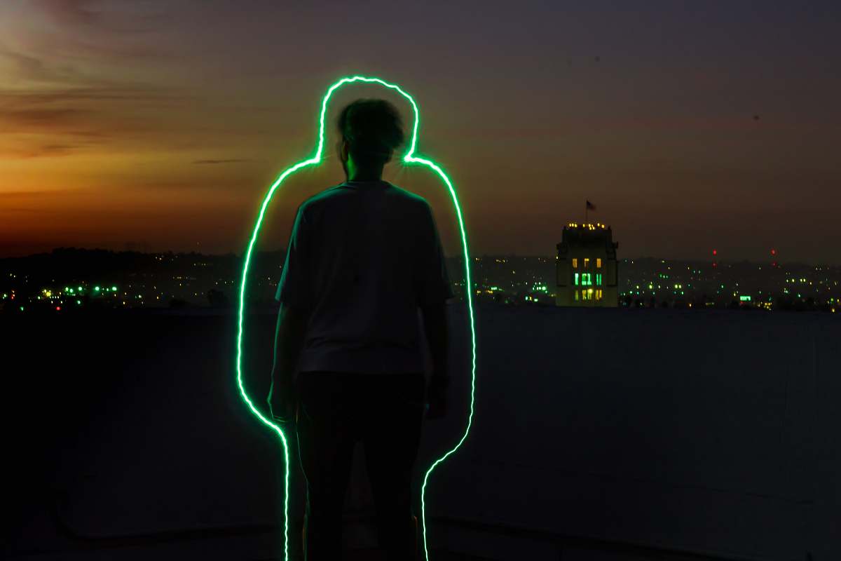 people silhouette of man standing with green neon outline during sunset human