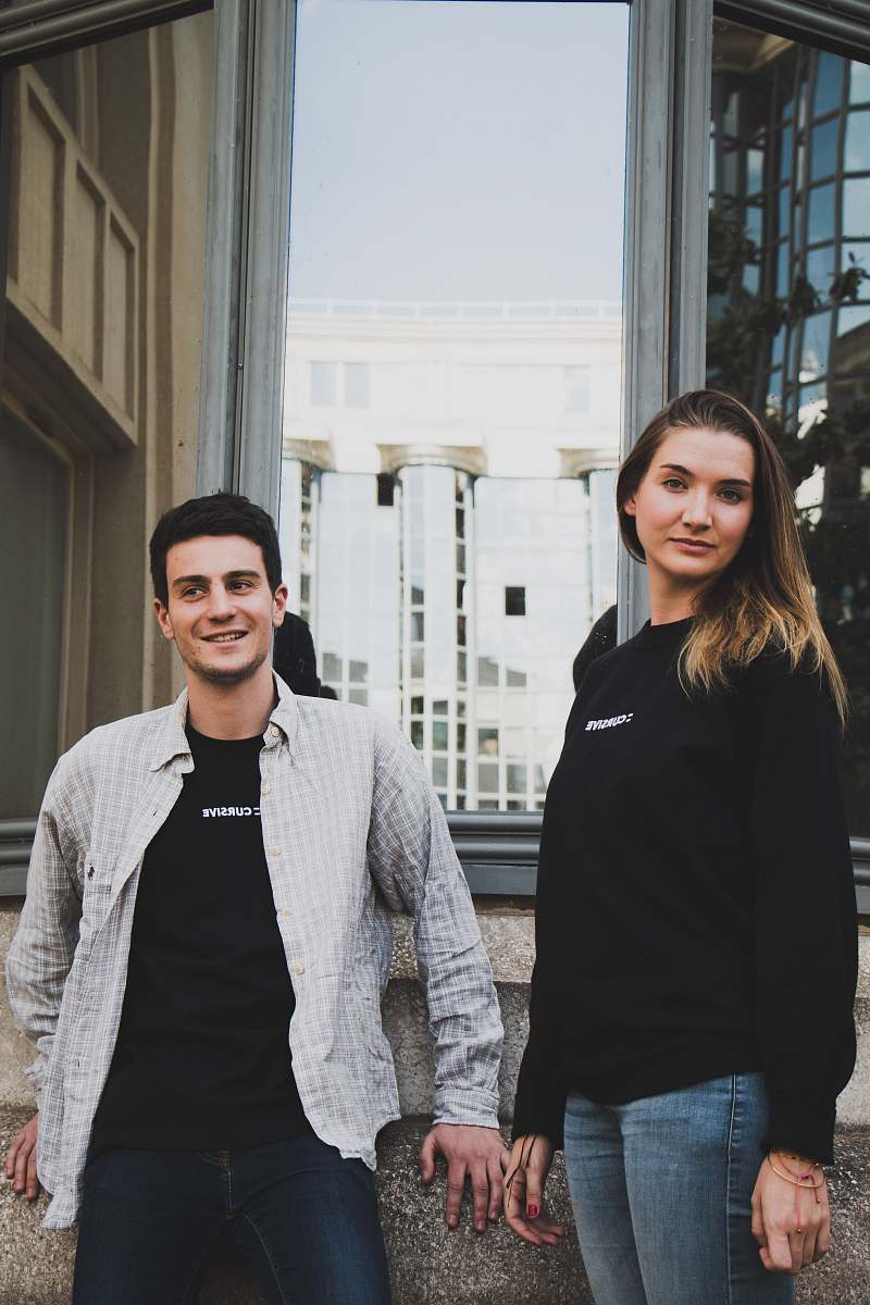 human smiling man and woman standing near white building people