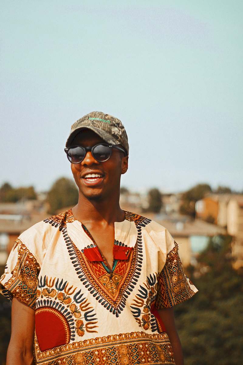 people smiling man wearing brown baseball cap under clear sky human