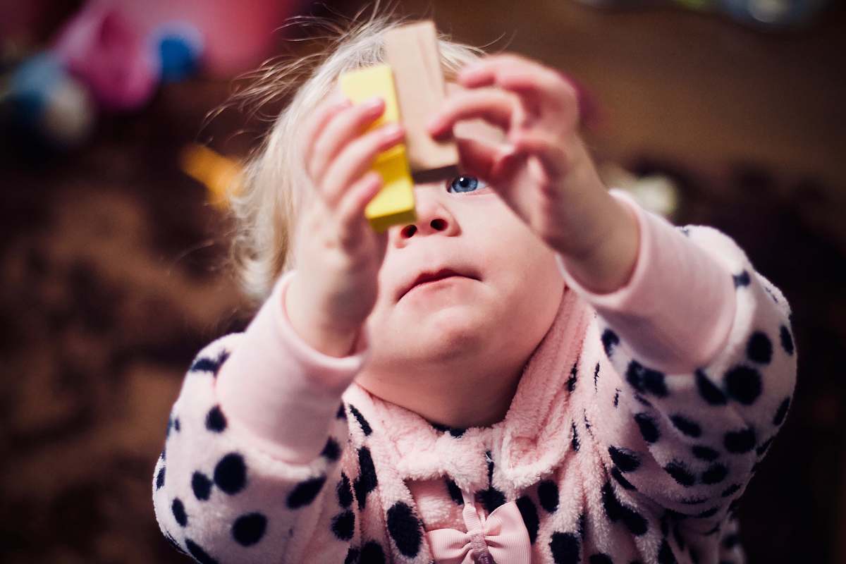 people toddler playing with two wooden blocks human