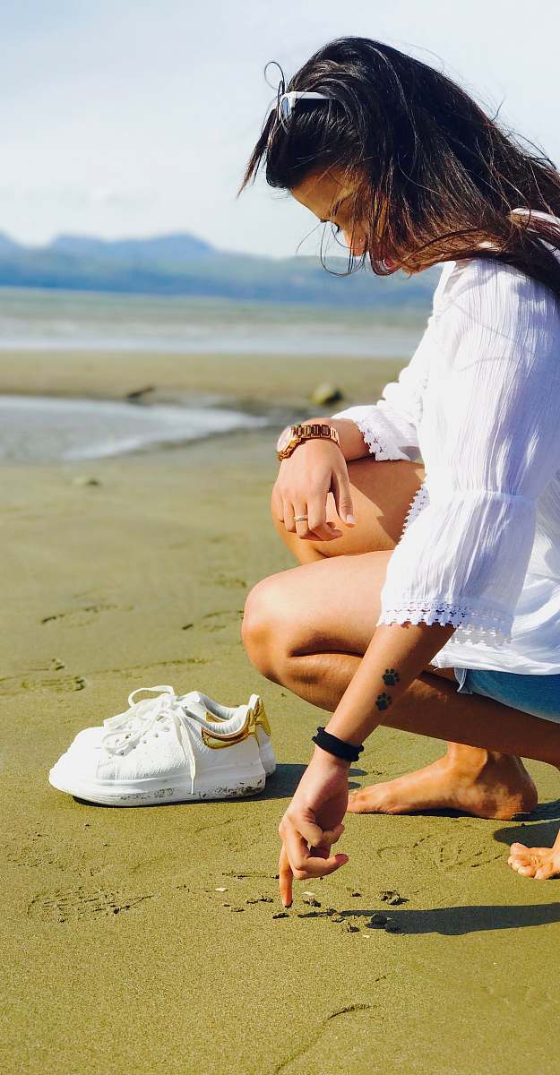 human woman about to write on the sand at daytime people