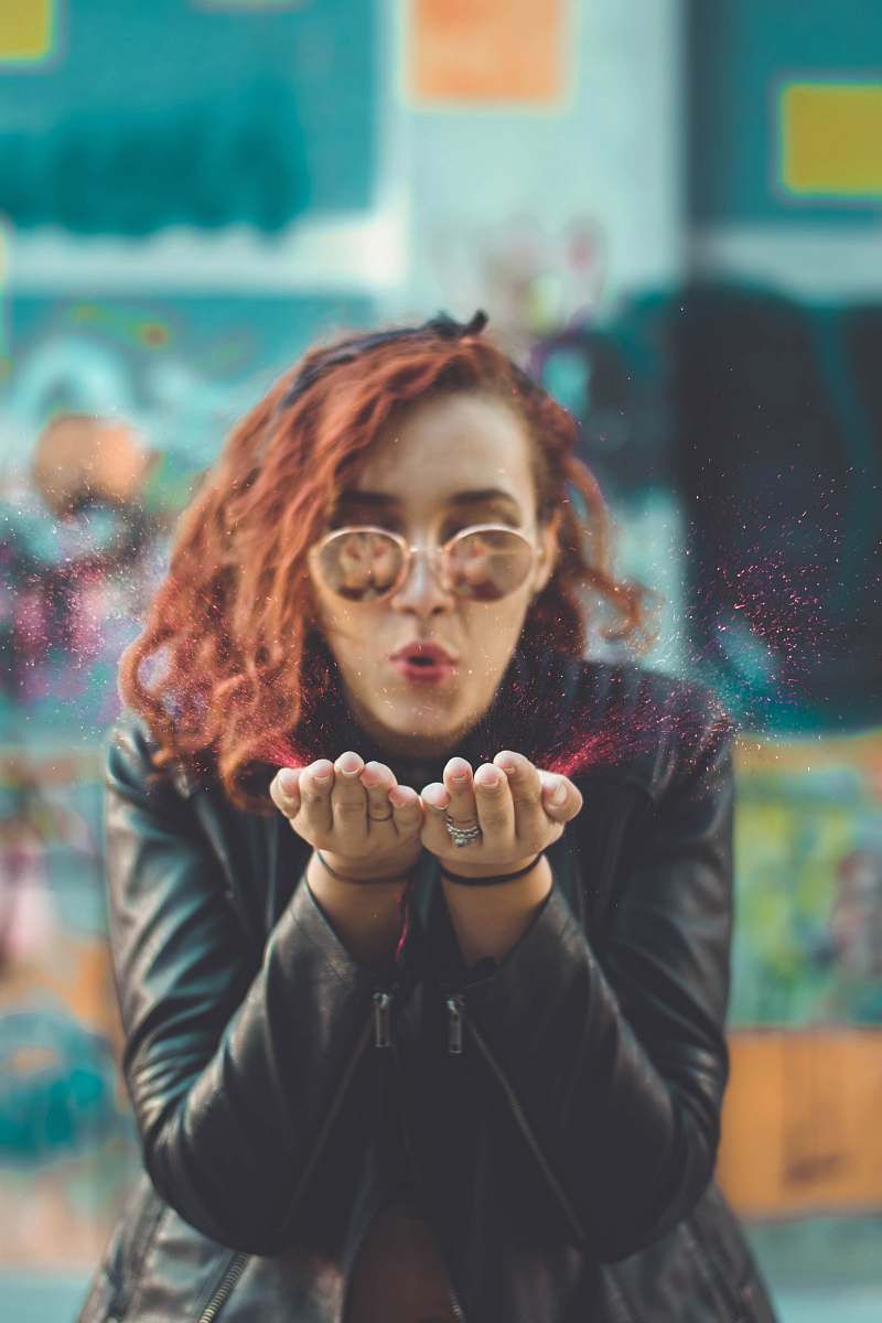 people woman blowing red powder from her hands human