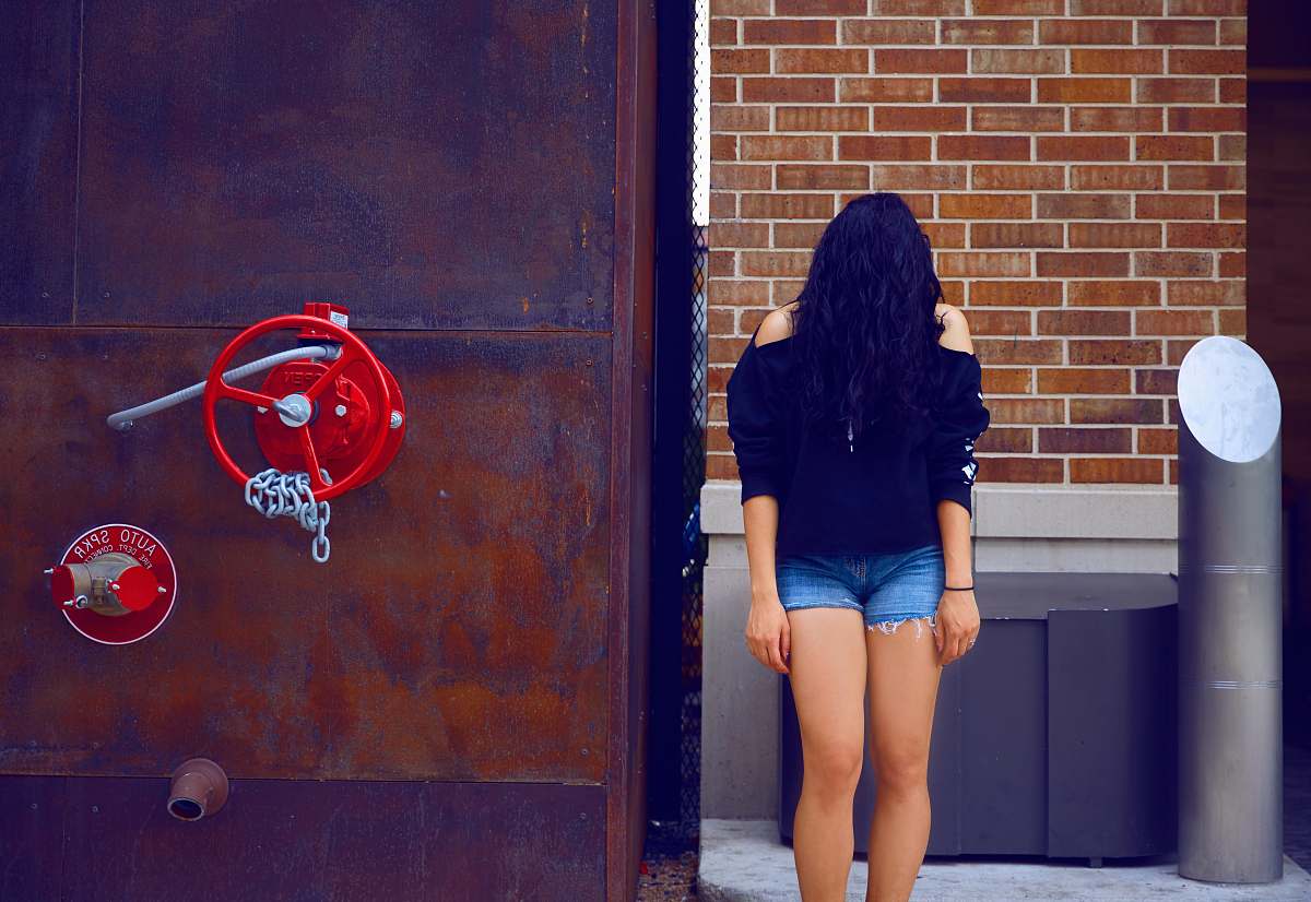 human woman covered with hair standing beside building people