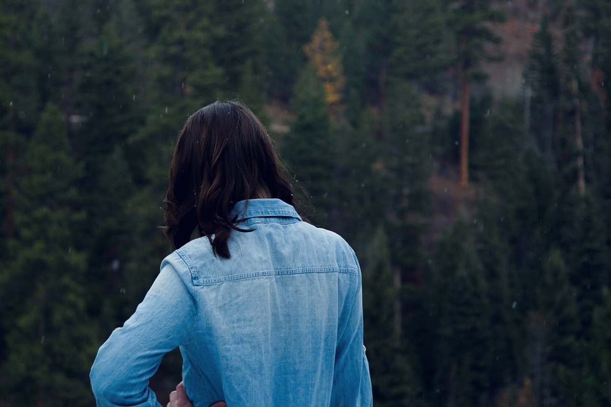 blue woman facing pine trees girl