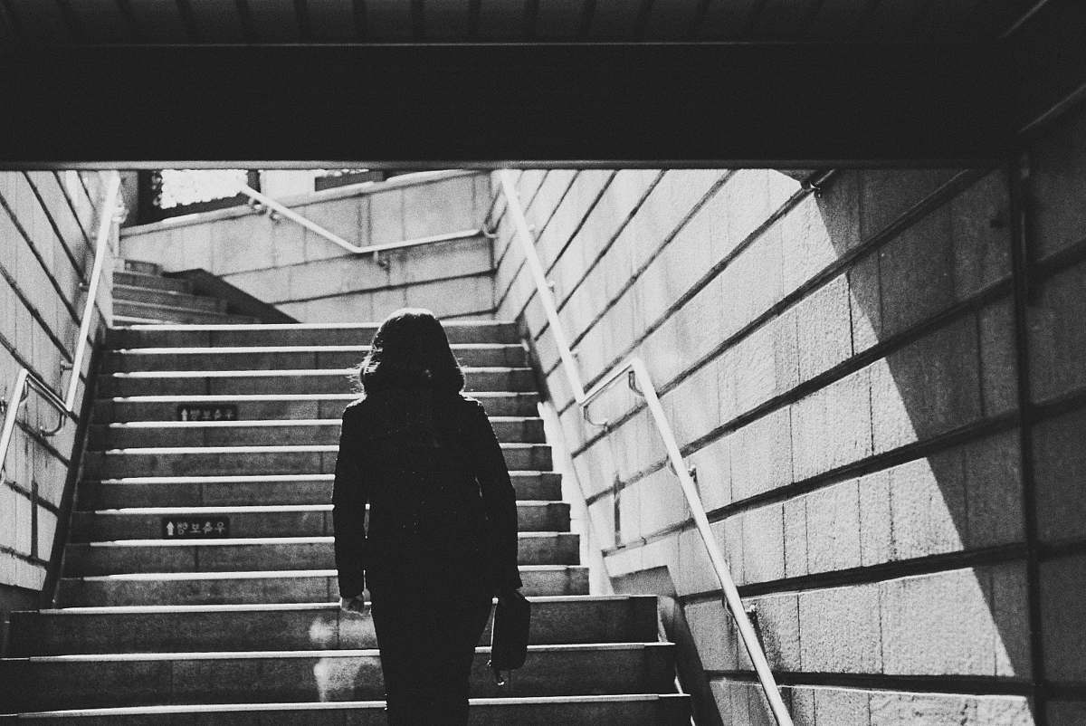black-and-white woman going upstairs grey