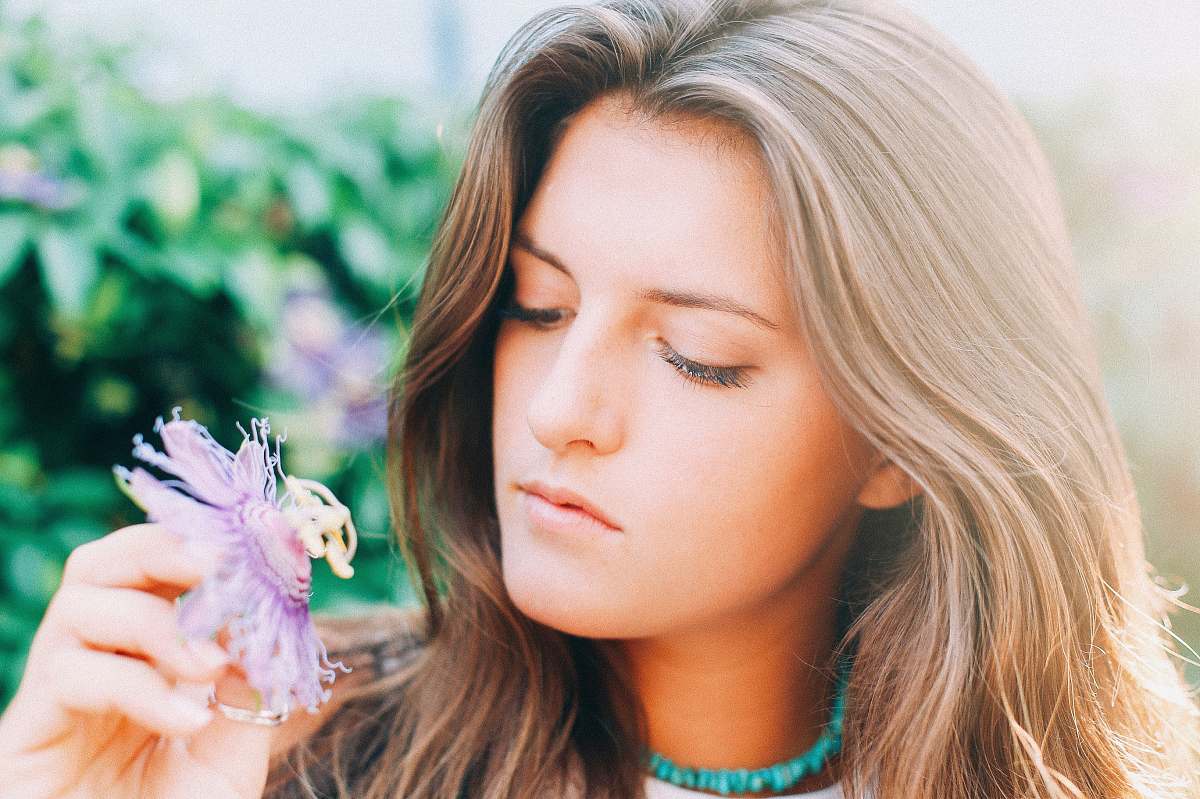 woman woman holding flower during daytime in selective focus photography girl