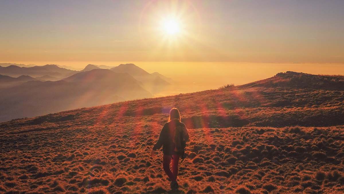 people woman in blue jacket walking on desert during sunset nature