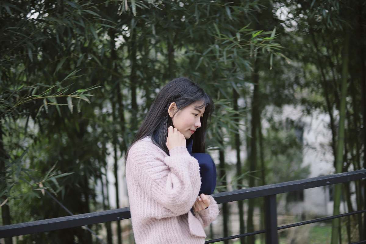 people woman in pink sweatshirt standing near fence human