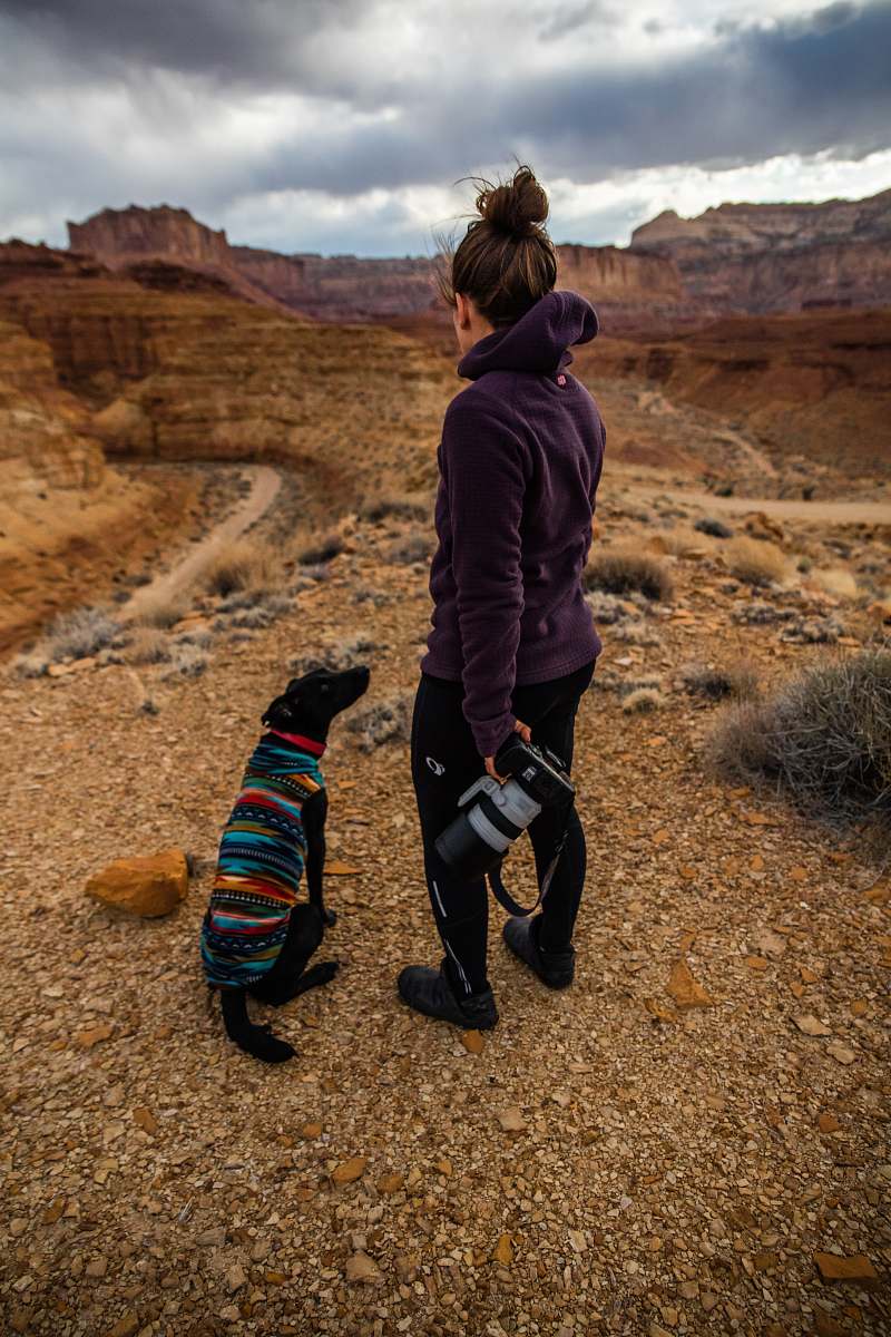 human woman in purple jacket staring at brown rock fragment people