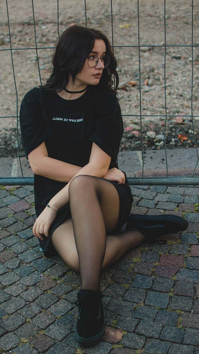 people woman sitting beside black fence human