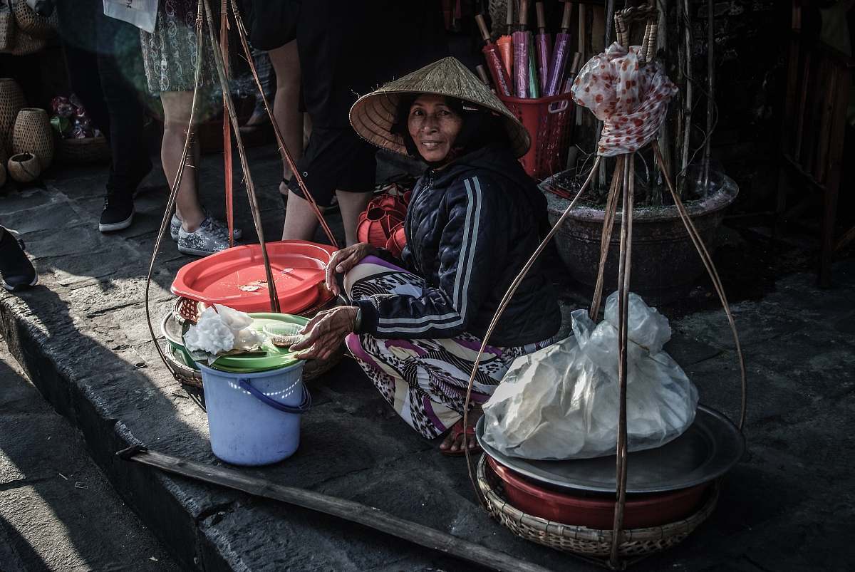 people woman sitting beside street bucket human
