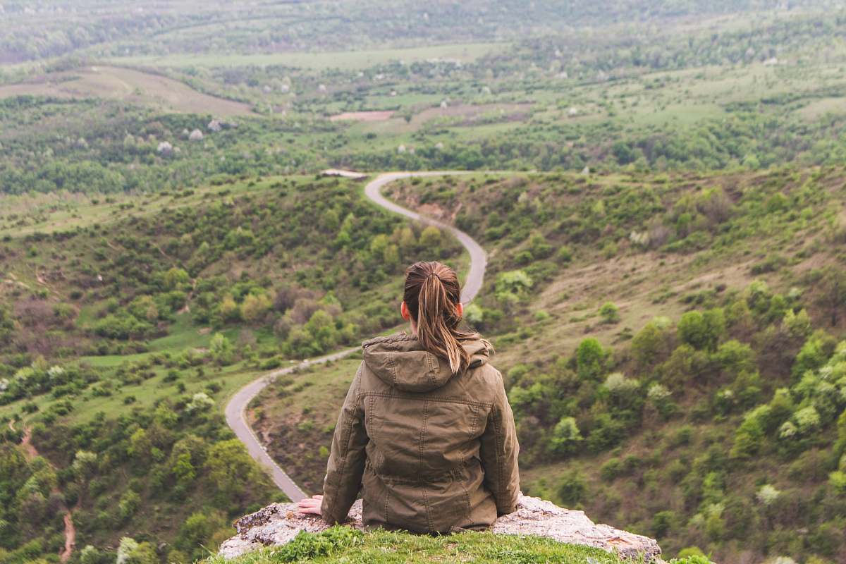 human woman sitting on grey cliff people