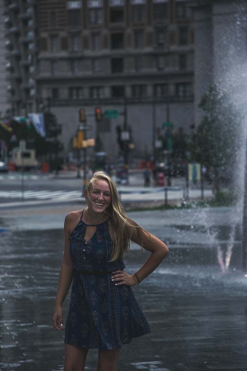 human woman standing in front of outdoor fountain people