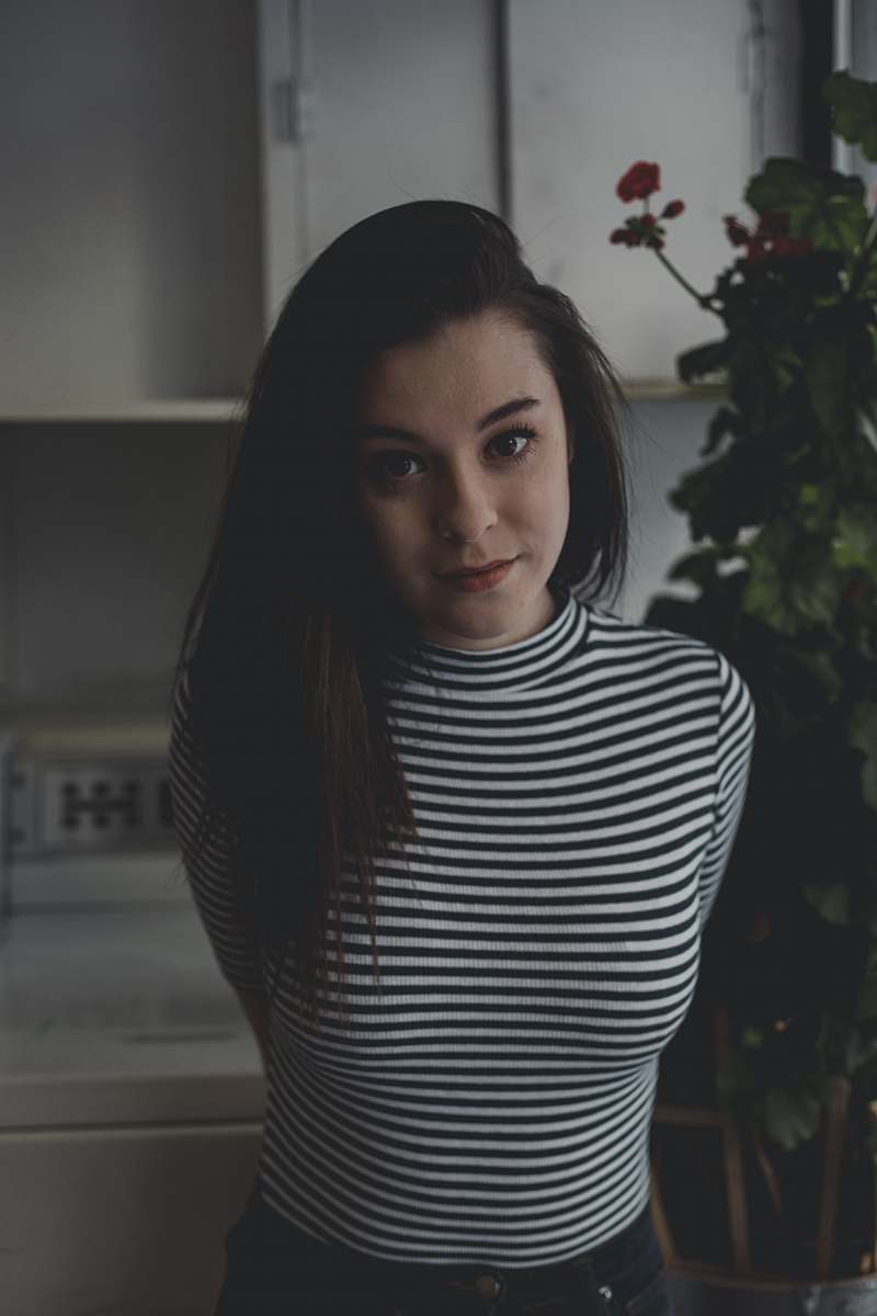 human woman standing near tall indoor plant people