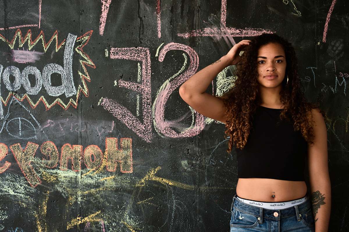 human woman standing near wall with graffiti people