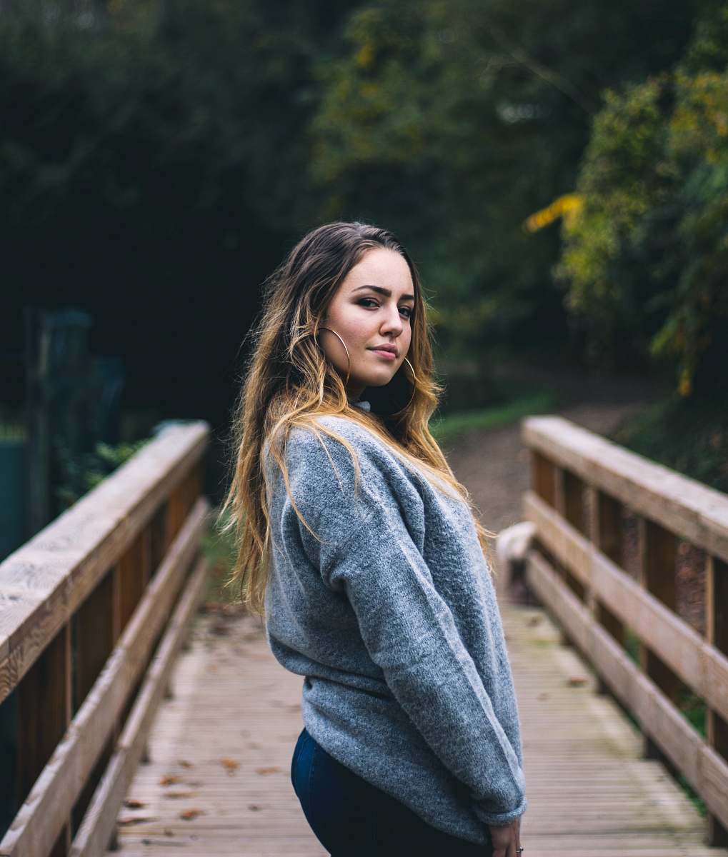 human woman standing on bridge taking a photo people
