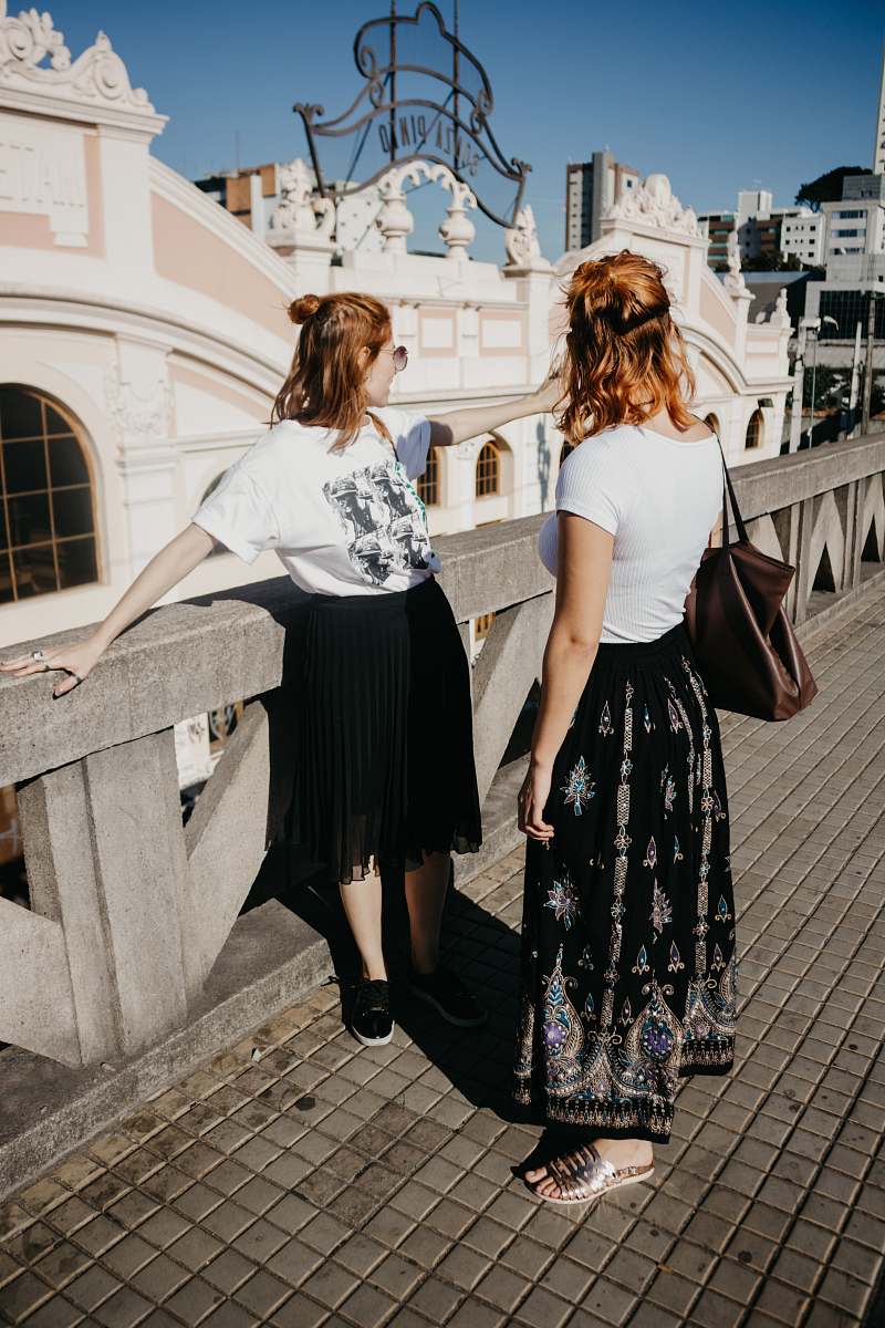 people woman standing on gray concrete road pointing direction during daytime human