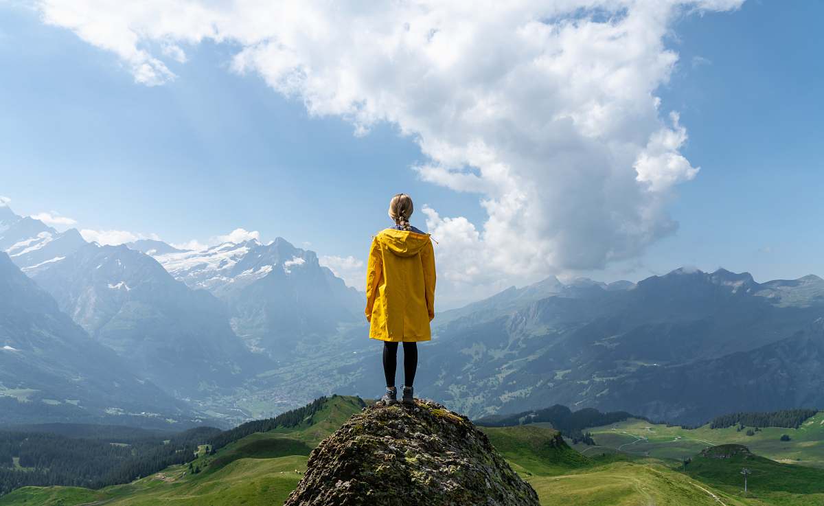 people woman standing on rock in front of mountain during daytime human