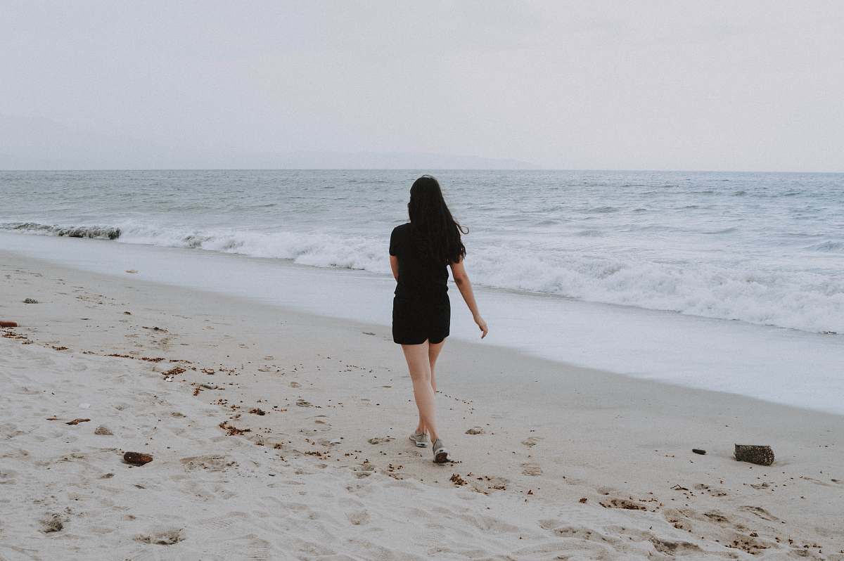 beach woman walking on beach shore coast
