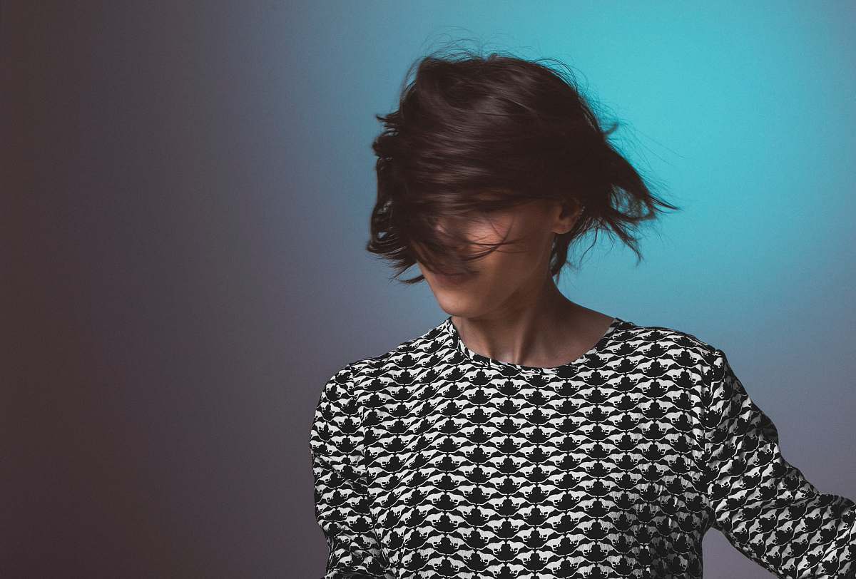 people Woman wearing a patterned sweater flips her short hair in front of her face human