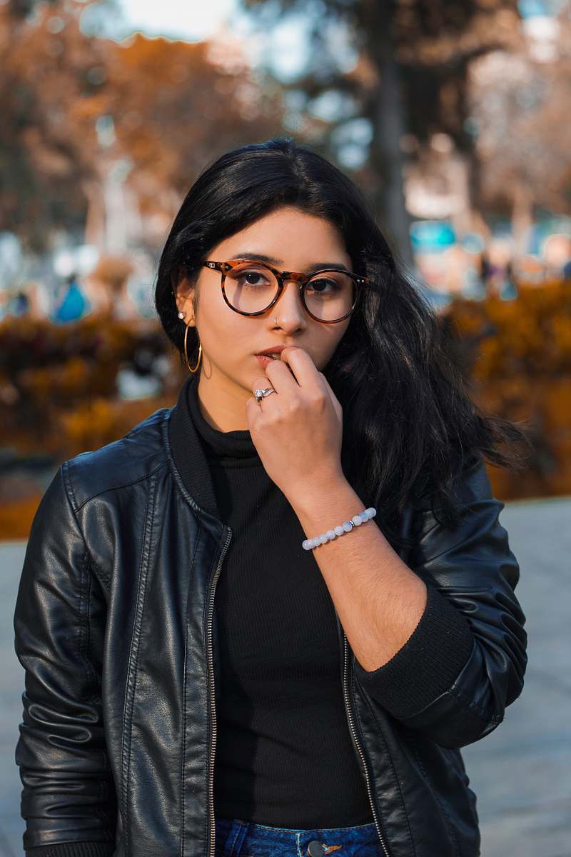human woman wearing black jacket standing near tree at daytime people