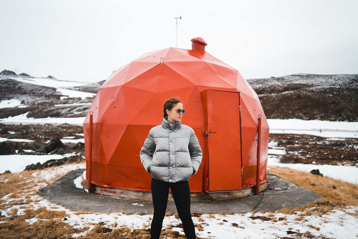 human woman wearing black pants near red metal dome house people