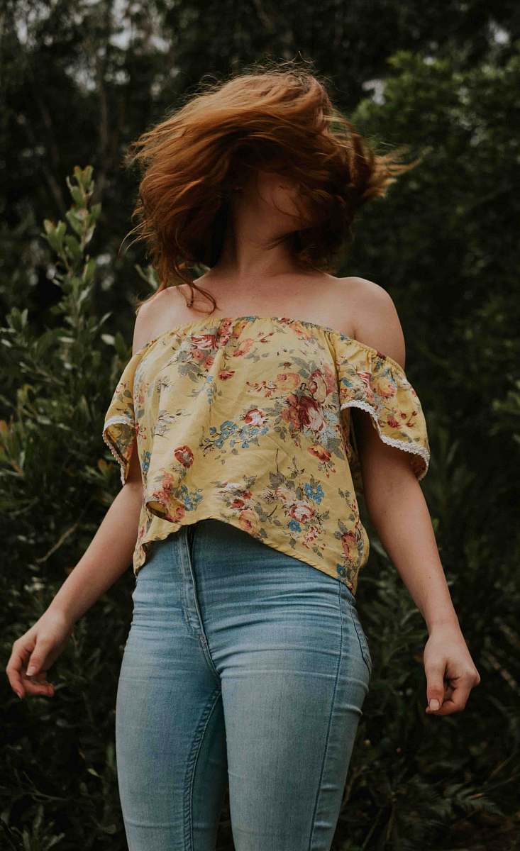 people woman wearing blue jeans standing behind plants human