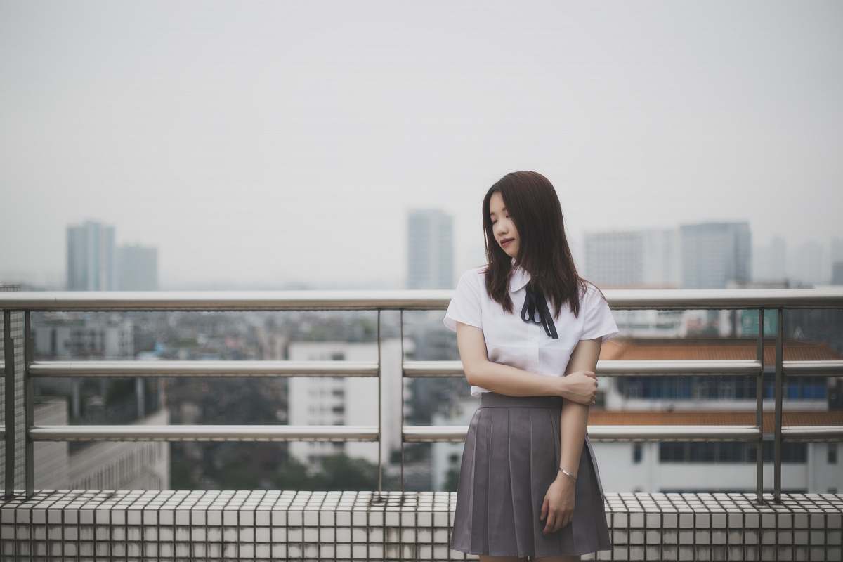 human woman wearing white button-up blouse and pleated skirt people