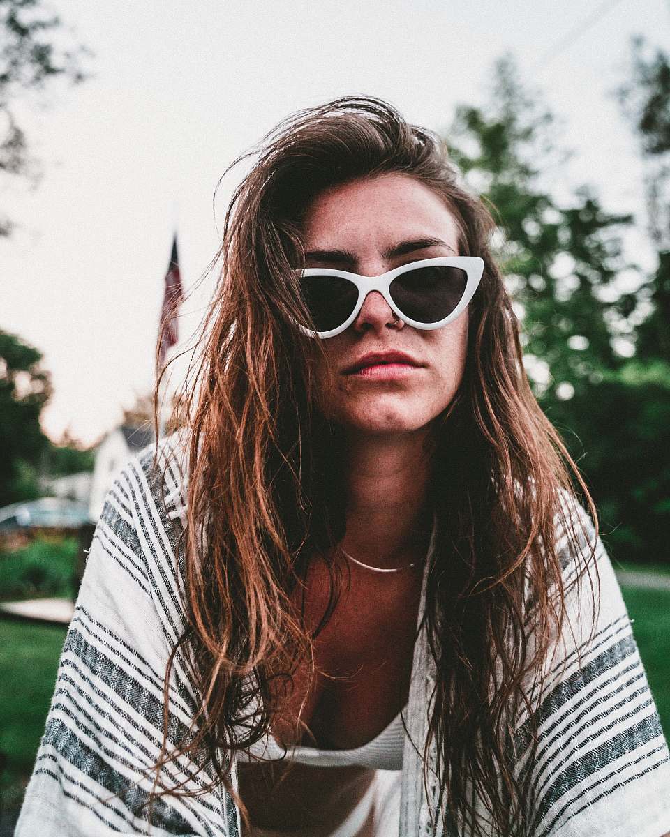 human women's black lens sunglasses and white bra people