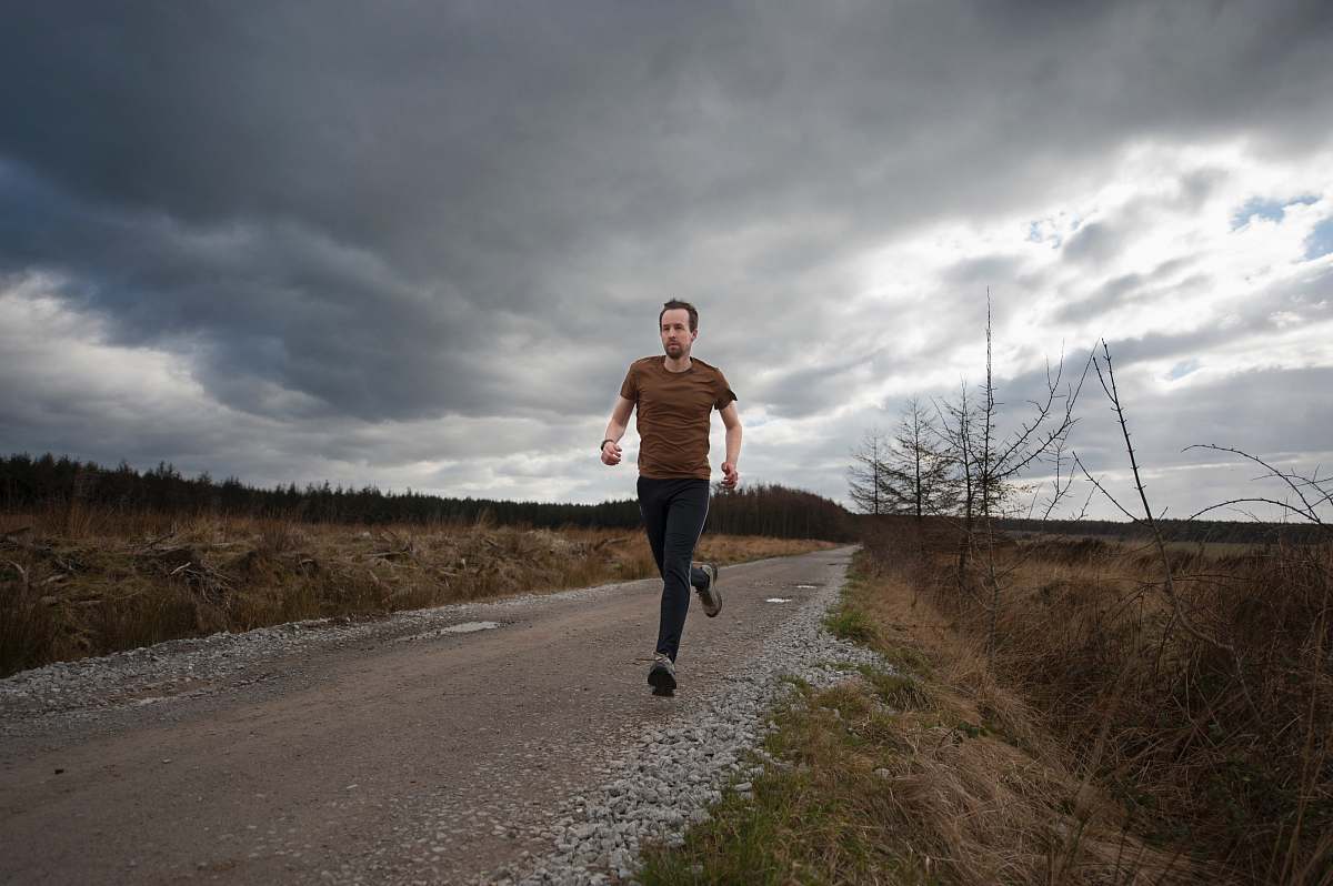 exercise man running at the road during daytime fitness