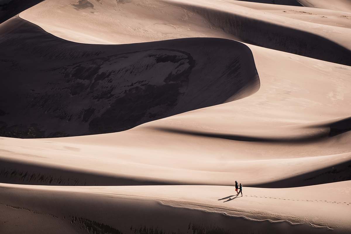 desert two person walking on desert during daytime nature