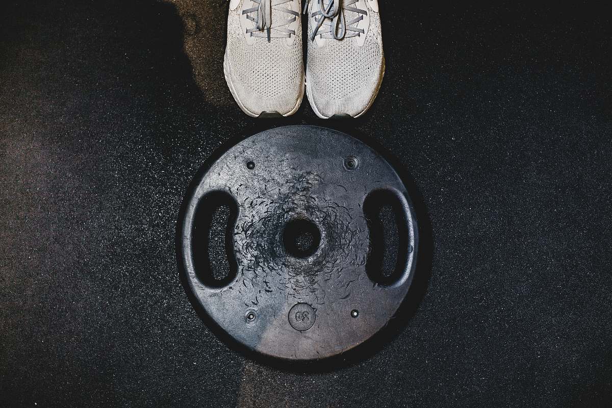 clothing black weight plate beside white sneakers grey