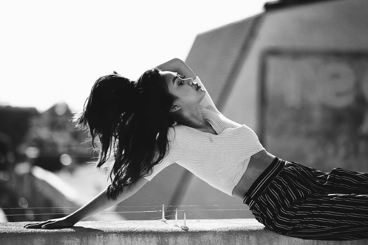 clothing grayscale photo of woman lean on concrete wall black-and-white