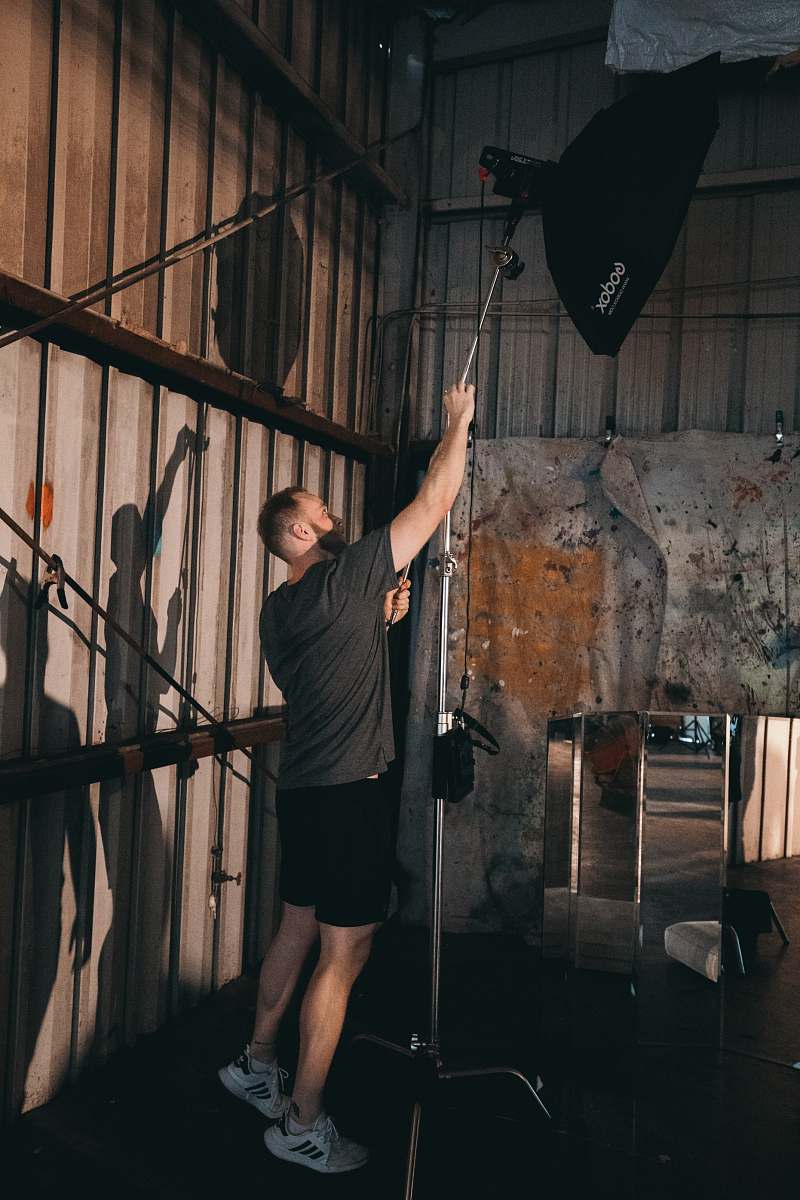 clothing man fixing a studio lamp shorts