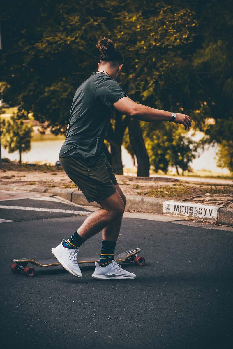 clothing man playing with a longboard footwear