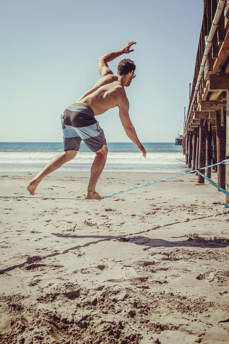 clothing man standing at beach during daytime shorts