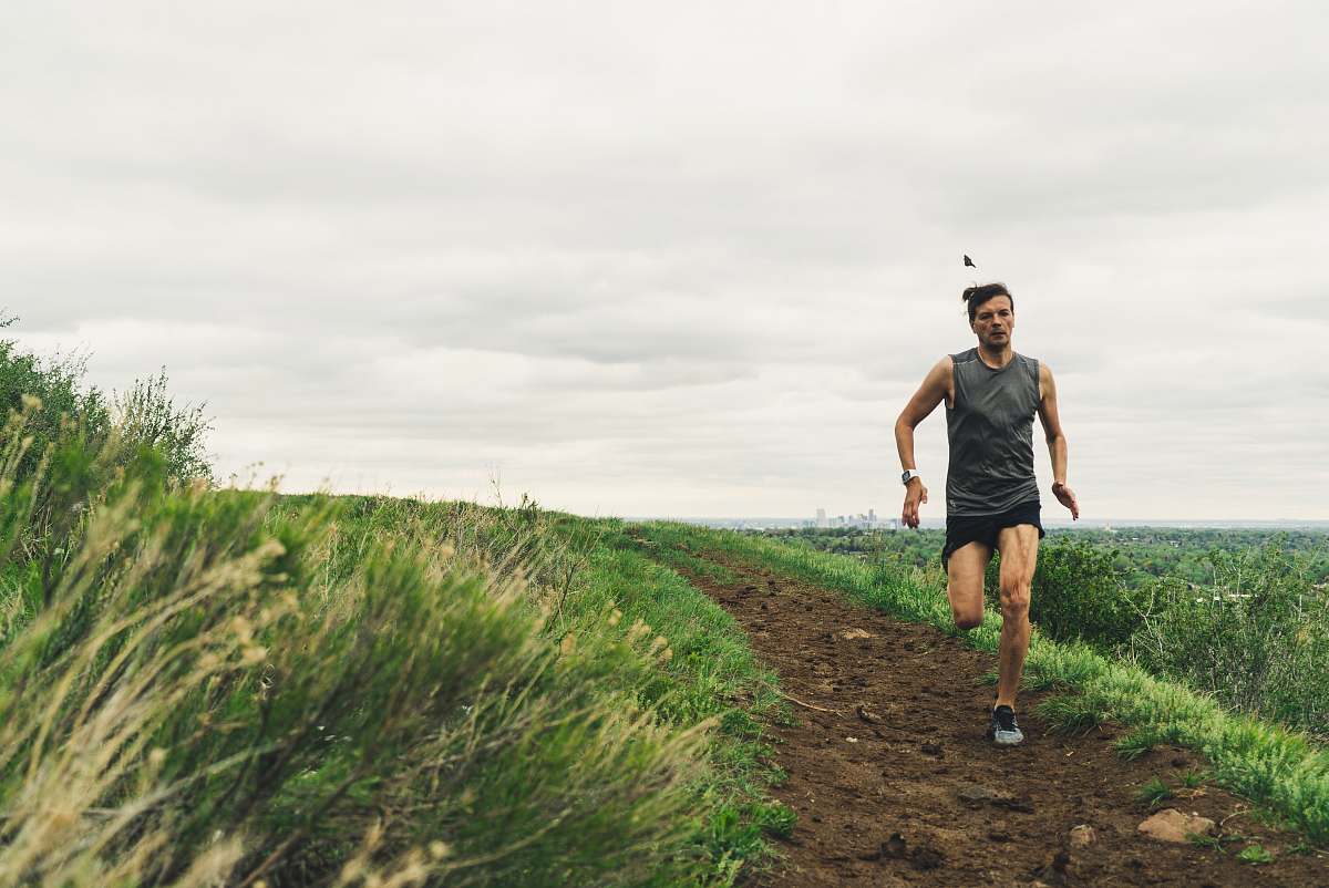 clothing man wearing gray tank top running during daytime shorts