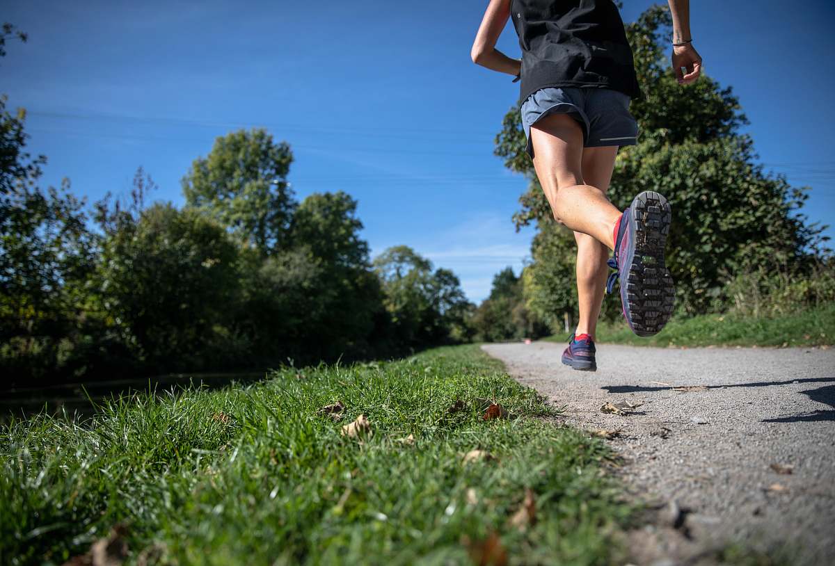 shorts person running between grass fields clothing