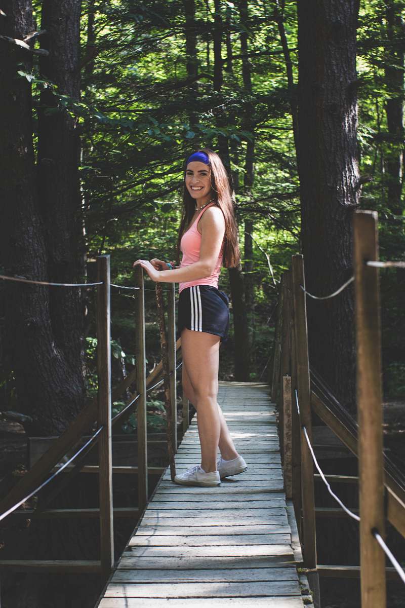 clothing woman wearing pink tank top standing on bridge shorts