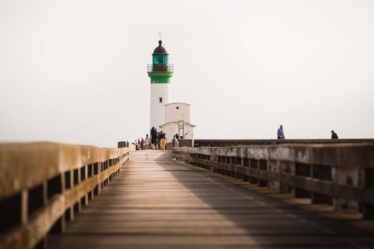 building person standing white and green lighthouse lighthouse