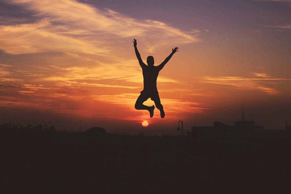 morocco silhouette of man jumping raising both hands during golden hour sky