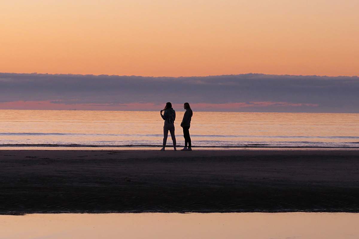 ocean silhouette of persons near in the beach sea