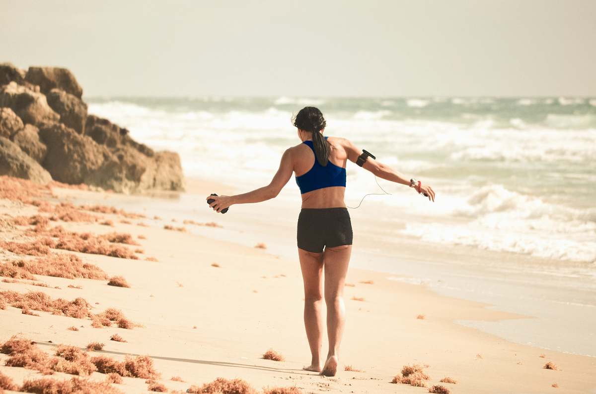 ocean woman walking on sand near seashore during daytime person