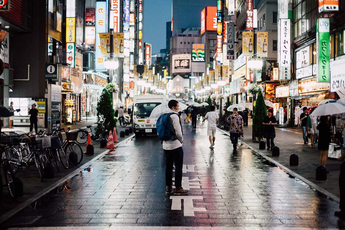 bicycle man with backpack standing on street during night time transportation