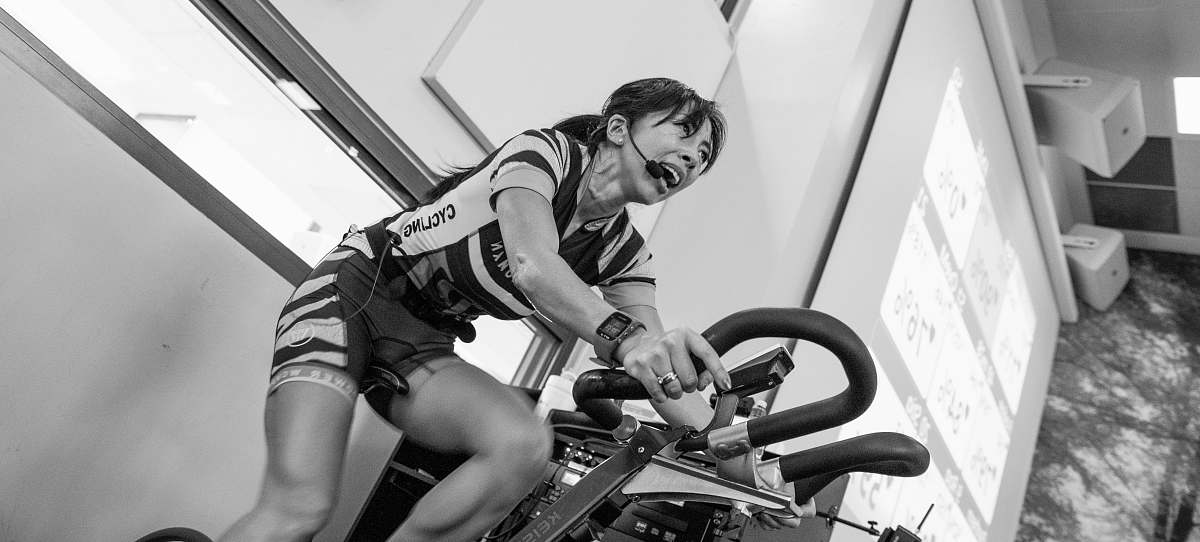bike grayscale photography of woman on elliptical trainer human