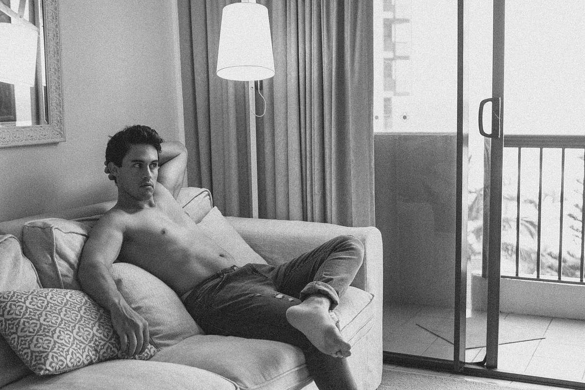 couch topless man sitting on gray sofa furniture