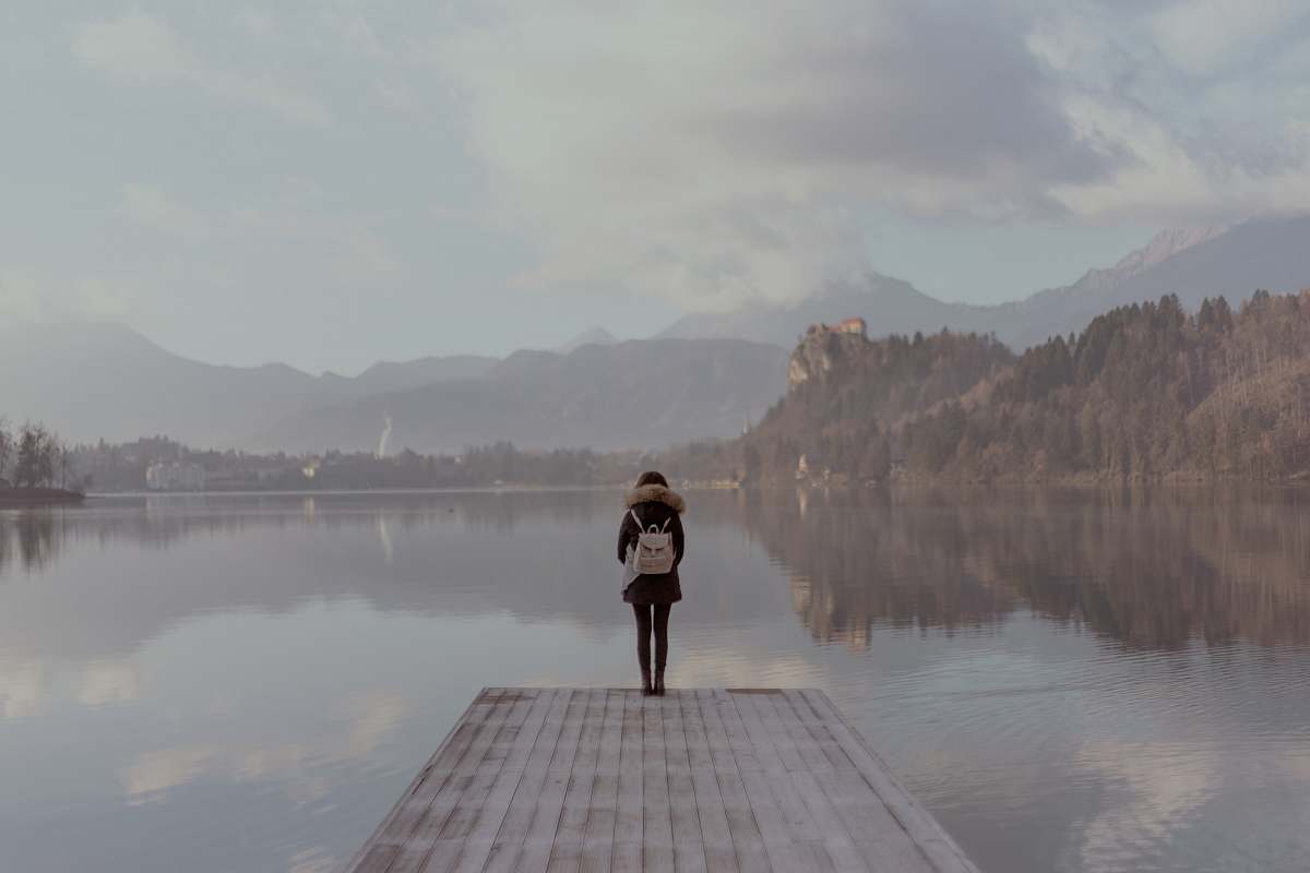 slovenia woman standing beside body of calm water grey