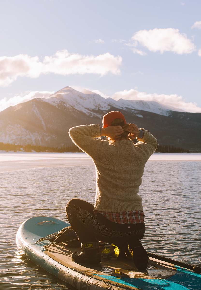 stretch person riding waveboard on body of water near mountain at daytime sports
