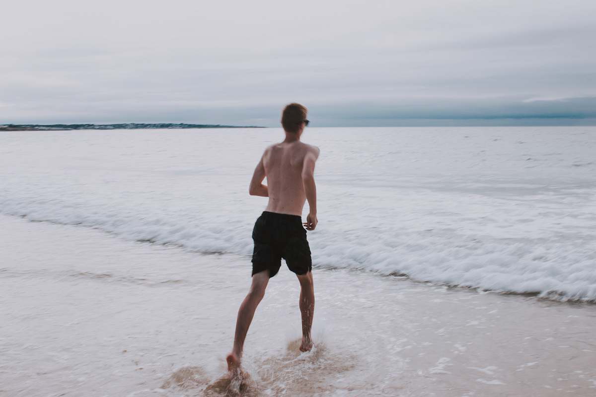 apparel man running on seashore shorts