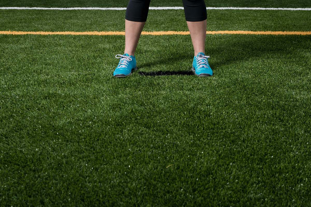 footwear person standing on green grass field shoe